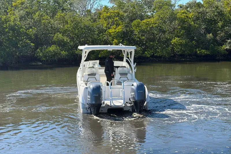 Slide: The Image of 2023 World Cat 255 DC boat navigating a calm river with lush greenery. - 9