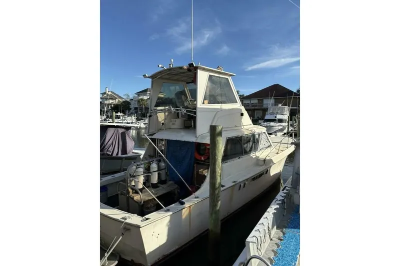 The Image of 1968 Hatteras 41 Convertible boat docked at marina under clear blue sky. - 1