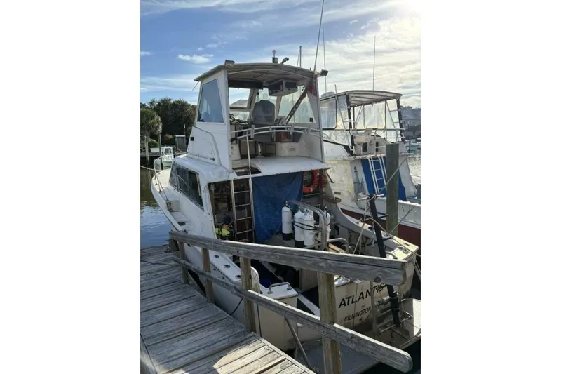 Slide: The Image of 1968 Hatteras 41 Convertible boat docked at marina under clear sky. - 3