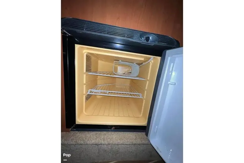 Slide: The Image of 2007 Maxum 2600 SE boat refrigerator interior with wire shelves. - 6