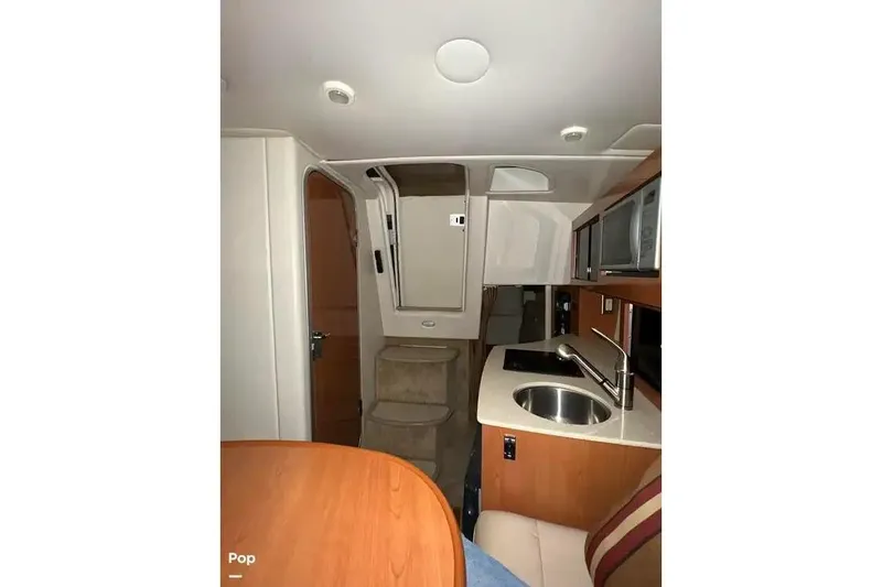 Slide: The Image of 2007 Maxum 2600 SE boat interior with kitchenette and seating area. - 8