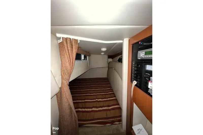 Slide: The Image of 2007 Maxum 2600 SE cabin interior with striped bedding and audio system. - 9