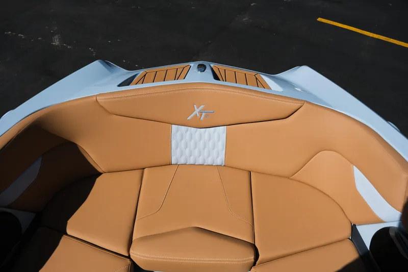 Slide: The Image of 2026 MasterCraft XT24 boat interior with tan and white seating, showcasing luxury design. - 14