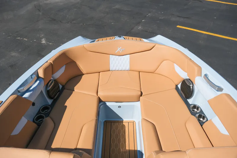 Slide: The Image of 2026 MasterCraft XT24 boat interior with tan leather seating and cup holders. - 16