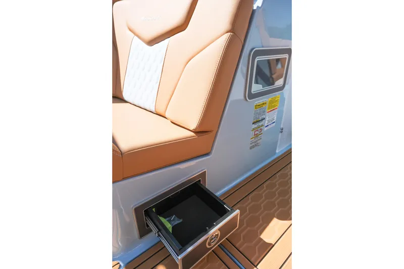 Slide: The Image of 2026 MasterCraft XT24 boat interior with tan seating and open storage drawer. - 17