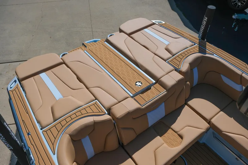 Slide: The Image of 2026 MasterCraft XT24 boat interior with tan and white cushioned seating. - 23