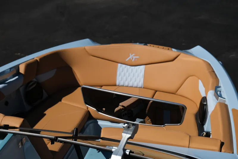Slide: The Image of 2026 MasterCraft XT24 boat interior with tan and white seating, featuring a sleek rearview mirror. - 24