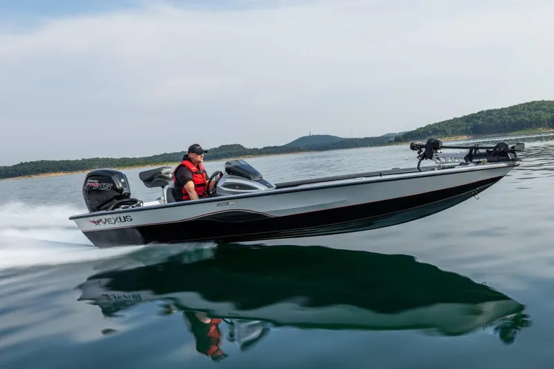 The Image of Manufacturer Provided Image: 2026 Vexus AVX 1880 boat cruising on a serene lake with a driver in a red life jacket. - 0