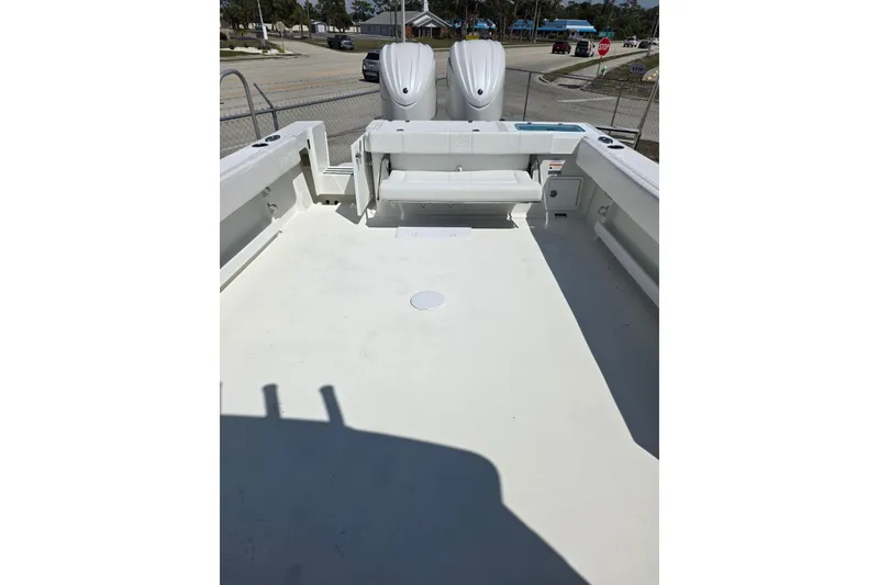 Slide: The Image of 2026 Parker 287 Explorer boat deck with seating and twin engines, parked near a street. - 17