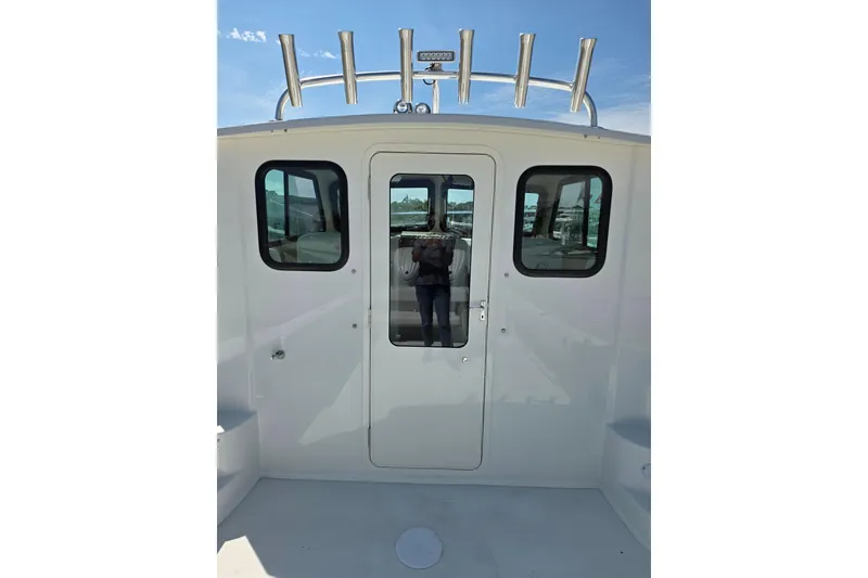 Slide: The Image of 2026 Parker 287 Explorer boat cabin entrance with windows and rod holders. - 18
