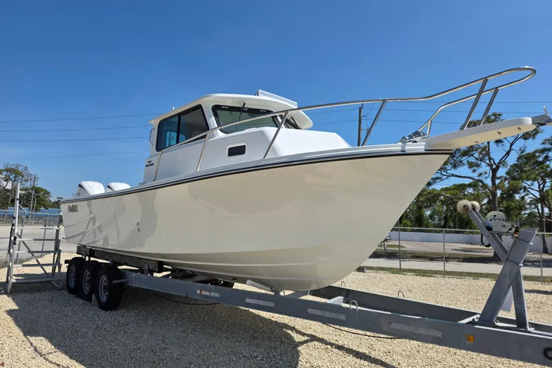 Slide: The Image of 2026 Parker 287 Explorer boat on trailer, displayed outdoors under clear blue sky. - 20