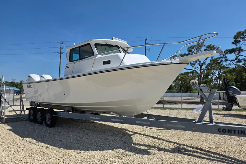 Slide: The Image of 2026 Parker 287 Explorer boat on trailer, displayed outdoors under clear blue sky. - 22