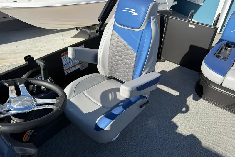 Slide: The Image of 2024 Bennington SSB-SPS boat interior with blue and gray captain's chair and steering wheel. - 13