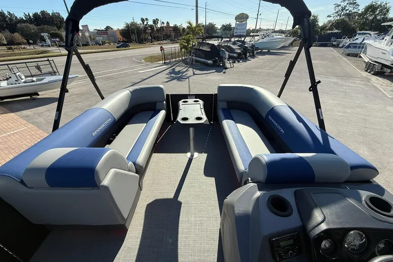 Slide: The Image of 2024 Bennington SSB-SPS pontoon boat interior with blue seating and central table. - 14