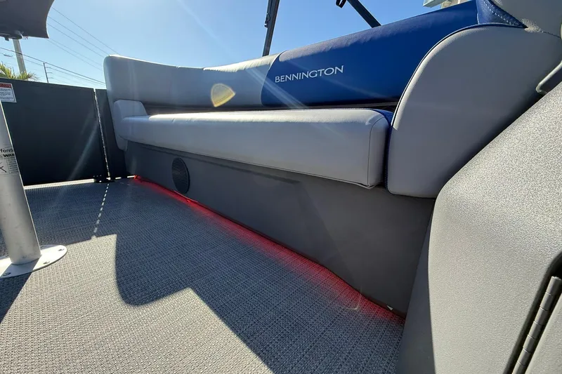 Slide: The Image of 2024 Bennington SSB-SPS boat interior with gray seating and red LED lighting. - 17