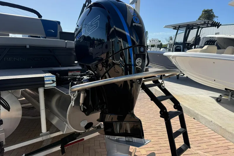 Slide: The Image of 2024 Bennington SSB-SPS boat with powerful outboard motor and ladder, docked on brick pavement. - 3