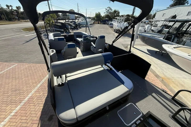 Slide: The Image of 2024 Bennington SSB-SPS pontoon boat with spacious seating, parked at a marina. - 5