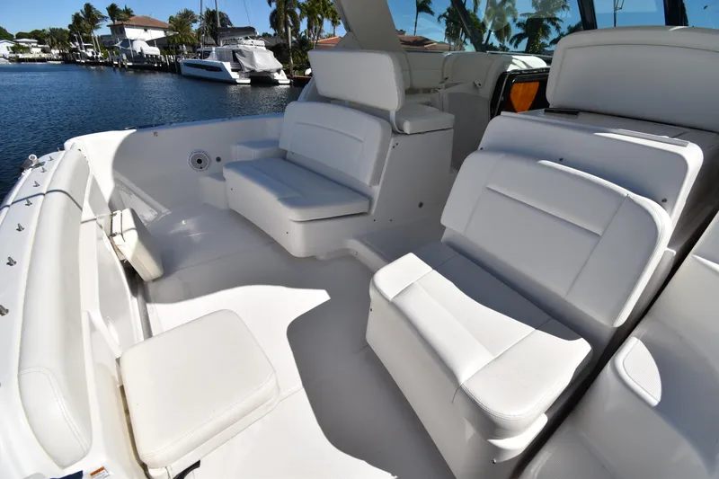 Slide: The Image of 2006 Tiara Yachts 3600 Open with white seating, docked by waterfront homes. - 11