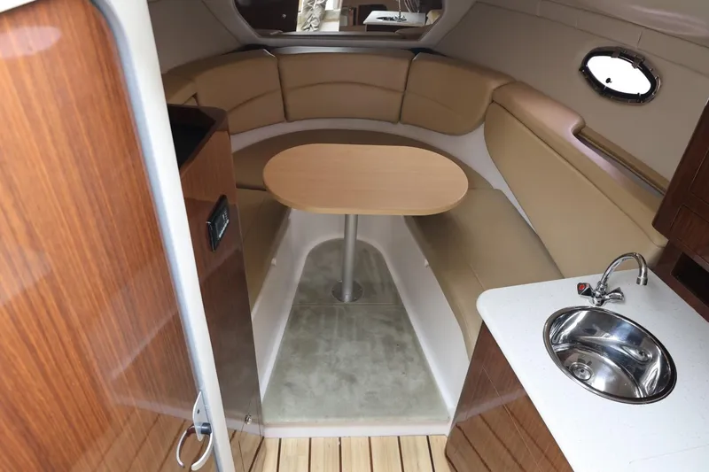 Slide: The Image of 2014 Regal 30 Express boat interior with seating, table, and sink. - 21