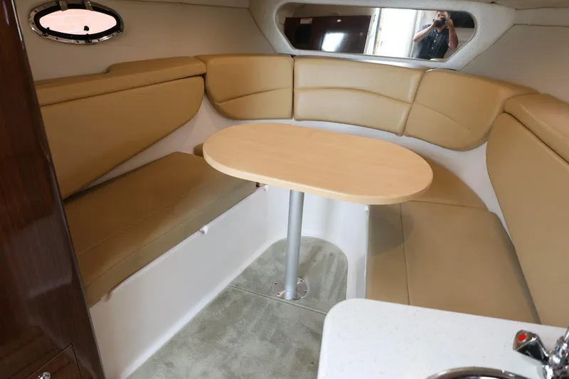 Slide: The Image of 2014 Regal 30 Express cabin interior with beige seating and a wooden table. - 23