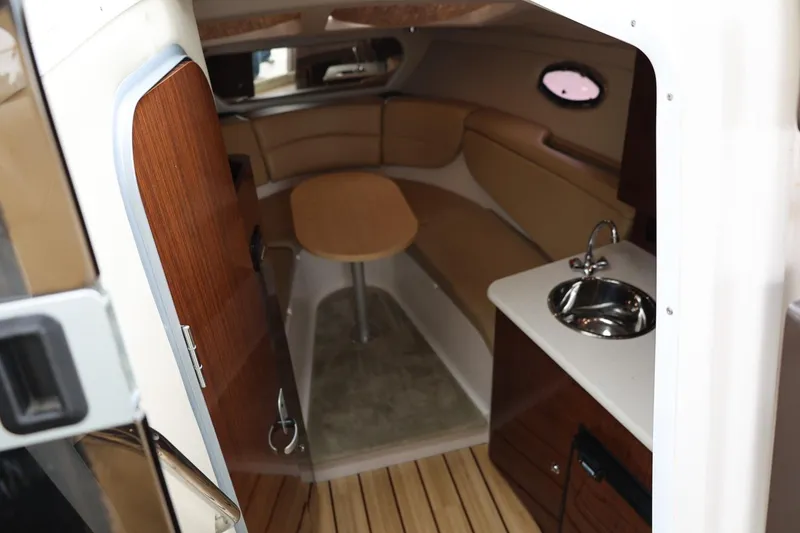 Slide: The Image of 2014 Regal 30 Express cabin interior with seating, table, and sink. - 29
