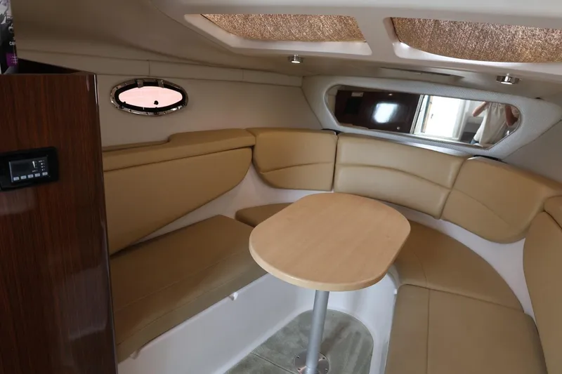 Slide: The Image of 2014 Regal 30 Express cabin interior with beige seating and wooden table. - 30