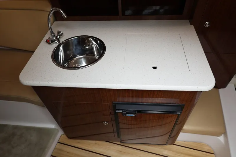 Slide: The Image of 2014 Regal 30 Express boat kitchenette with sink and countertop. - 32