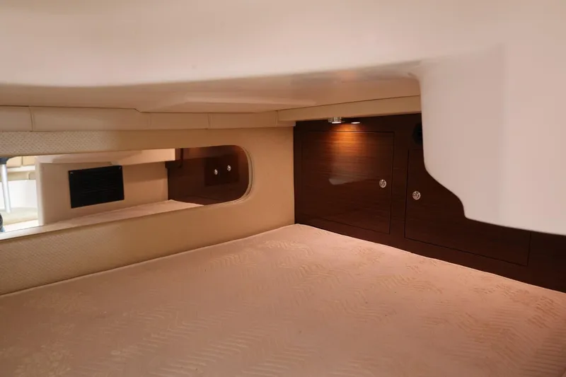 Slide: The Image of 2014 Regal 30 Express cabin interior with cozy bed and wooden storage cabinets. - 41