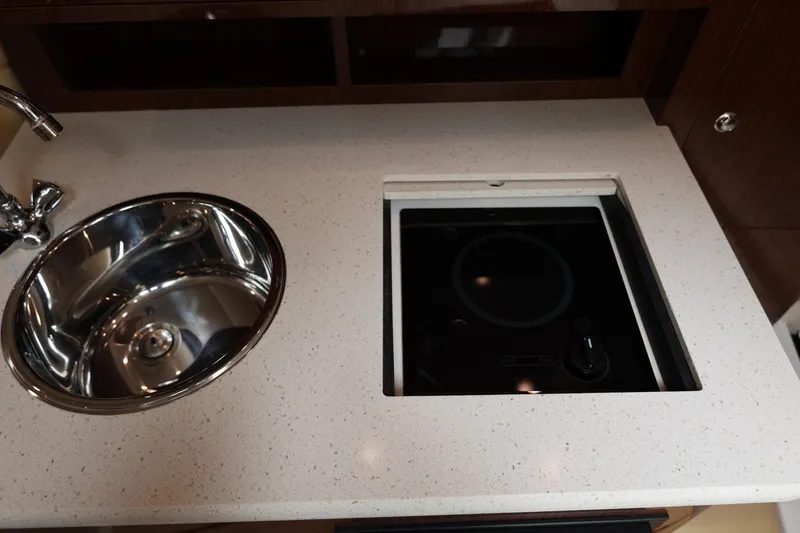 Slide: The Image of 2014 Regal 30 Express yacht kitchen with stainless steel sink and electric cooktop. - 43