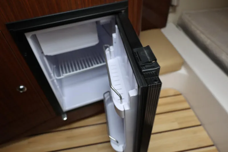 Slide: The Image of Open mini fridge inside 2014 Regal 30 Express boat cabin. - 44