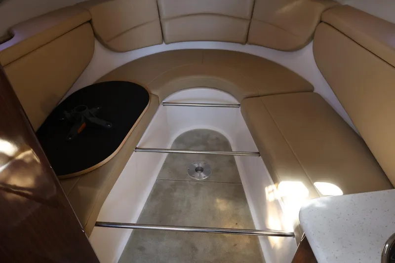 Slide: The Image of 2014 Regal 30 Express boat interior with beige seating and a small table. - 68