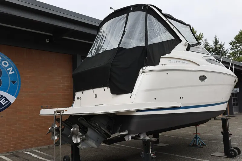 Slide: The Image of 2014 Regal 30 Express boat on stands, covered, with dual propellers. - 7