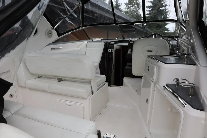 Slide: The Image of 2014 Regal 30 Express boat interior with white seating and kitchenette. - 9