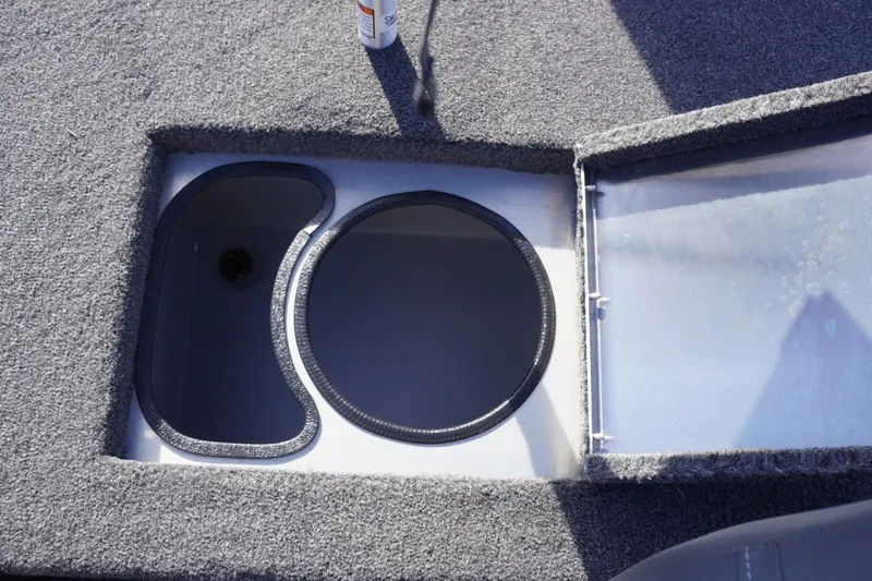 Slide: The Image of Storage compartment in 2025 Lowe Skorpion 17 boat, featuring carpeted interior and open lid. - 27