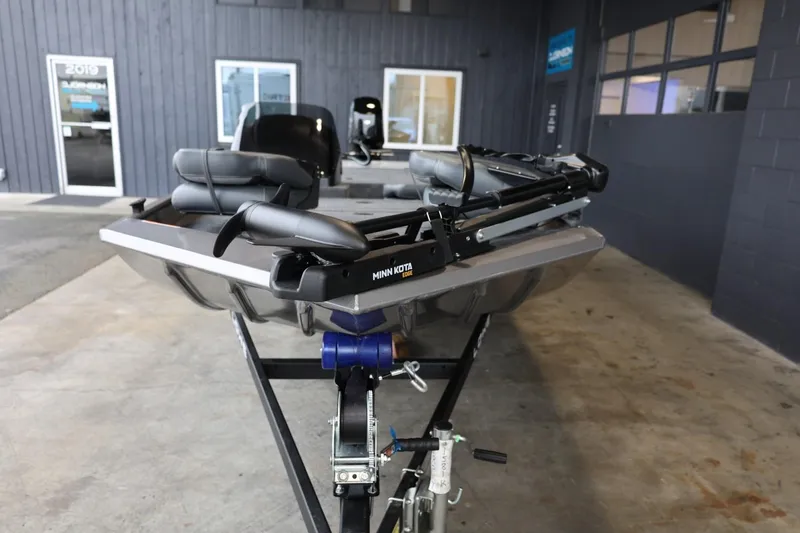 Slide: The Image of 2025 Lowe Skorpion 17 boat on trailer in showroom, featuring Minn Kota trolling motor. - 3