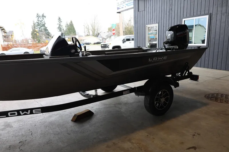 Slide: The Image of 2025 Lowe Skorpion 17 boat on trailer, parked indoors, with Mercury outboard motor. - 5