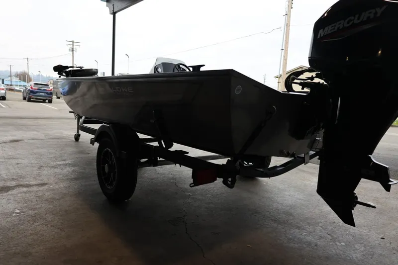 Slide: The Image of 2025 Lowe Skorpion 17 boat on trailer with Mercury outboard motor in a garage. - 6