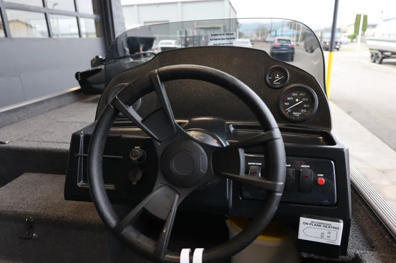 Slide: The Image of 2025 Lowe Skorpion 17 boat dashboard with steering wheel and gauges in a showroom. - 8