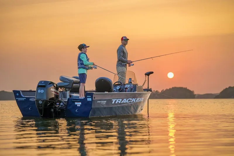 Slide: The Image of Manufacturer Provided Image: Two people fishing on a 2026 Tracker Pro Guide V-16 SC boat at sunset. - 59
