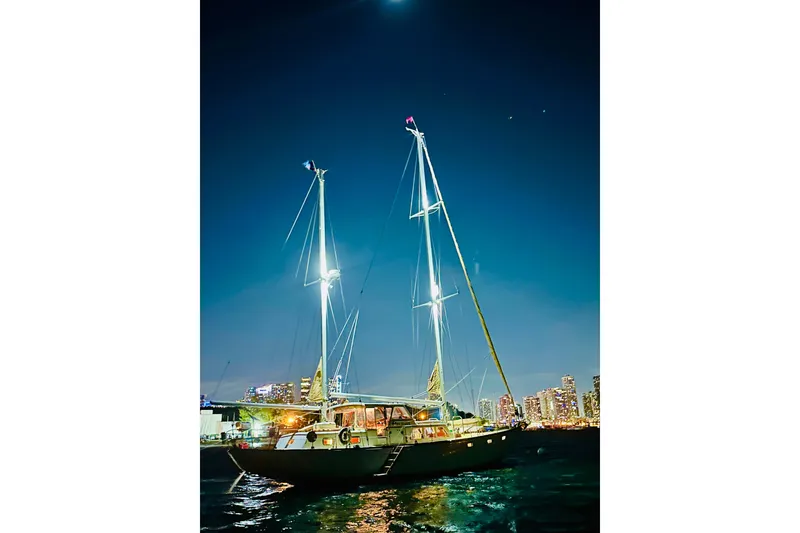 Slide: The Image of Sailboat "Alden Boothbay Explorer" 1971 at night, illuminated against city skyline. - 23