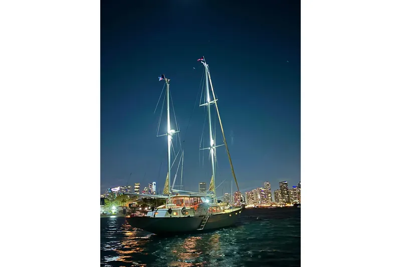Slide: The Image of Sailboat "Alden Boothbay Explorer" 1971 at night with city skyline backdrop. - 24