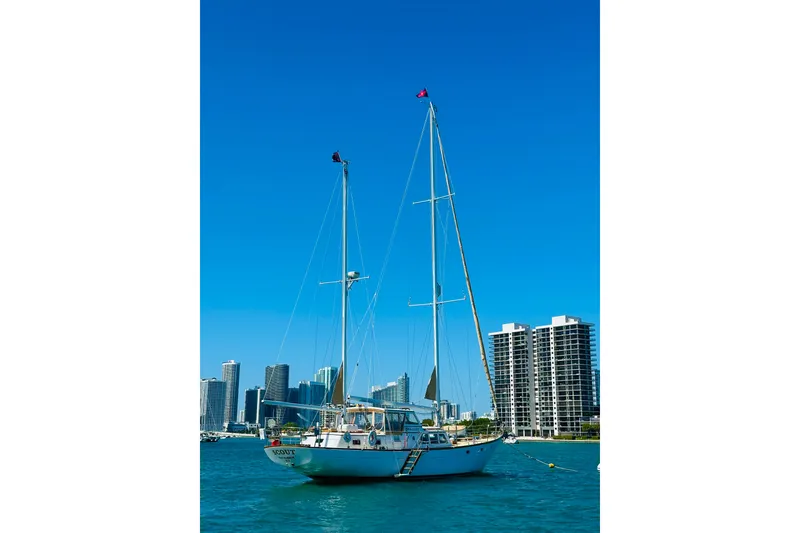 Slide: The Image of Alden Boothbay Explorer 1971 sailboat on water with city skyline background. - 28