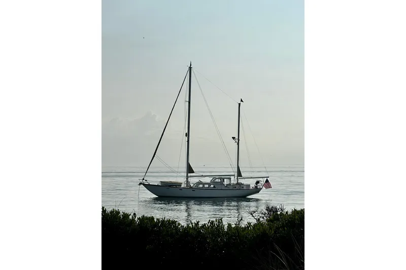 Slide: The Image of Sailboat Alden Boothbay Explorer 1971 on calm water with American flag. - 30