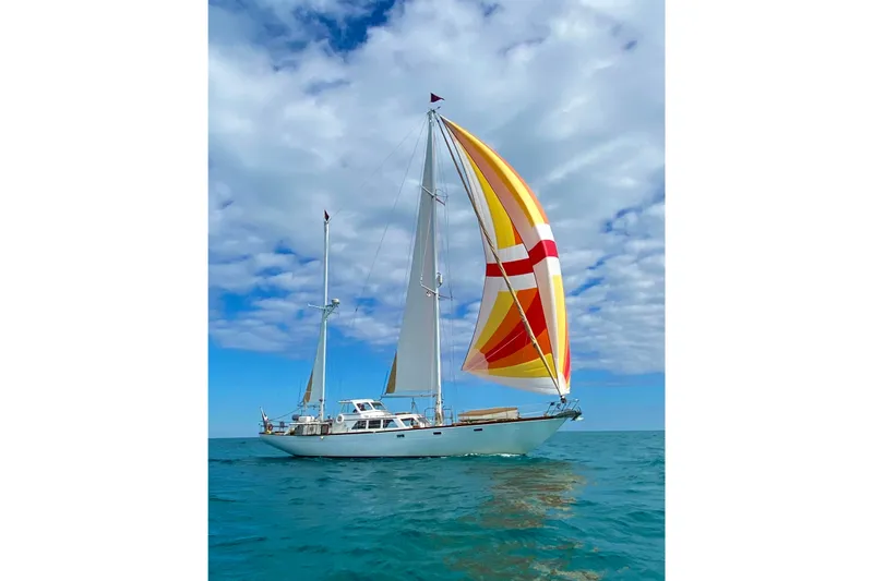 Slide: The Image of 1971 Alden Boothbay Explorer sailboat with colorful sails on open sea under blue sky. - 31