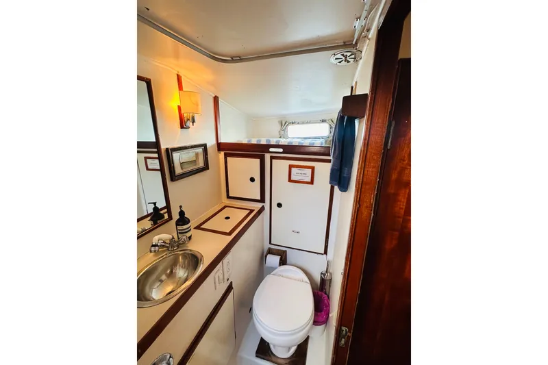 Slide: The Image of 1971 Alden Boothbay Explorer yacht bathroom with sink, toilet, and wooden accents. - 43