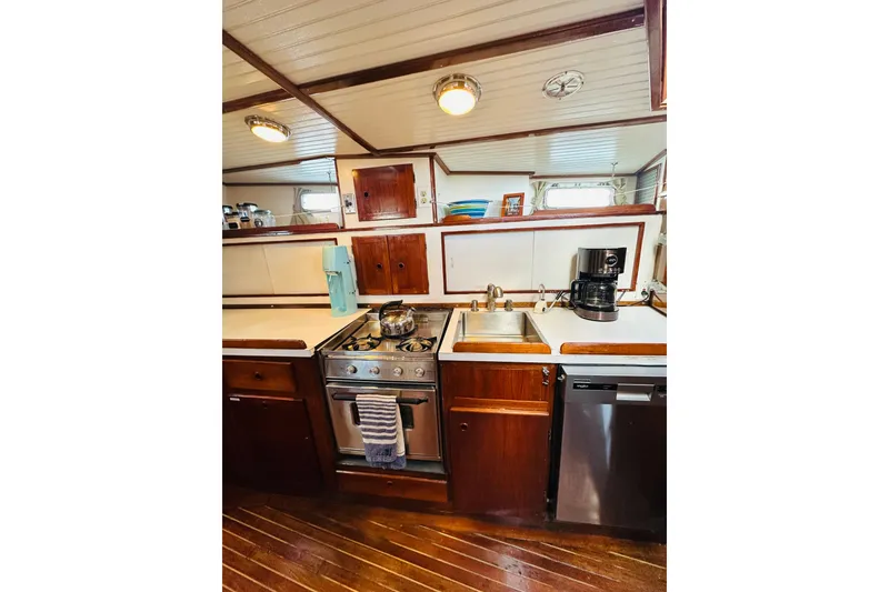 Slide: The Image of 1971 Alden Boothbay Explorer yacht kitchen with stove, sink, and wooden cabinetry. - 50