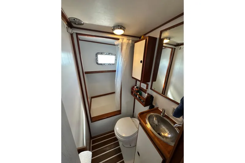 Slide: The Image of 1971 Alden Boothbay Explorer bathroom with shower, sink, and wooden accents. - 60