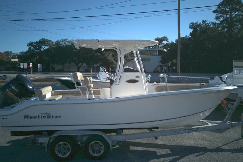 The Image of 2019 NauticStar 2200XS Offshore boat on trailer, side view. - 0