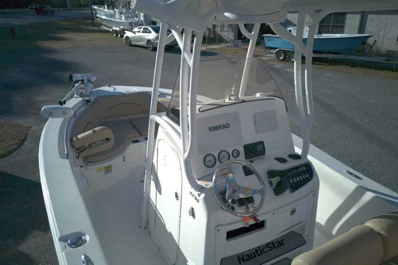 Slide: The Image of 2019 NauticStar 2200XS Offshore boat interior with steering console and seating. - 5