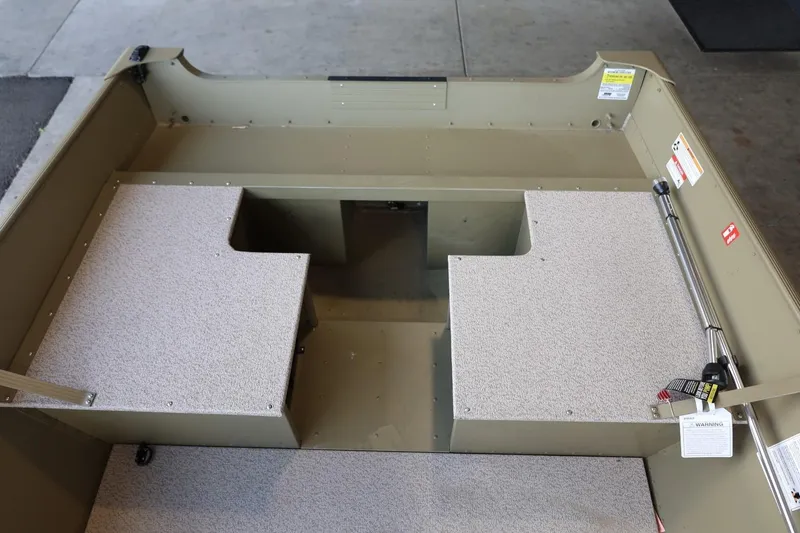 Slide: The Image of 2025 Lund SSV-18 Tiller boat interior with carpeted seating and storage compartments. - 16